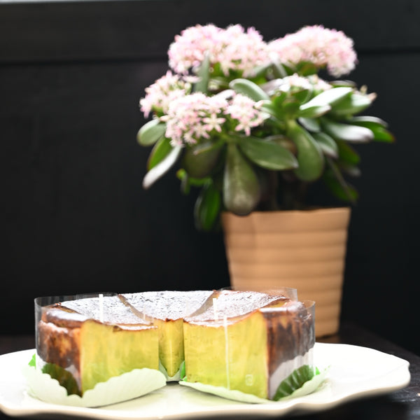 バスクチーズケーキの断面写真。ピンク色の花と共に。